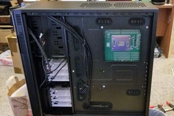 My server motherboard mounted in my PC case, with custom mounting holes.