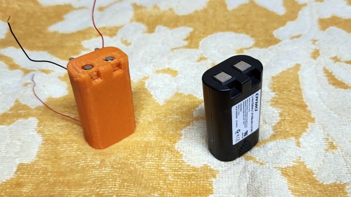 The original Dymo PnP battery beside my replacement; front view.