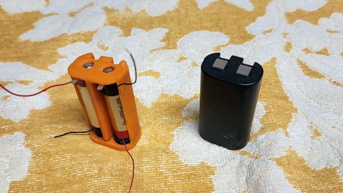 The original Dymo PnP battery beside my replacement; rear view.