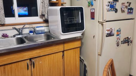 The dishwasher, in place between the sink and the fridge.